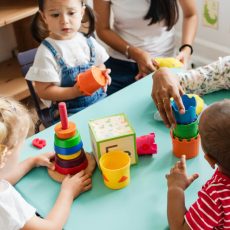 Teacher and toddlers playing with stacking toys