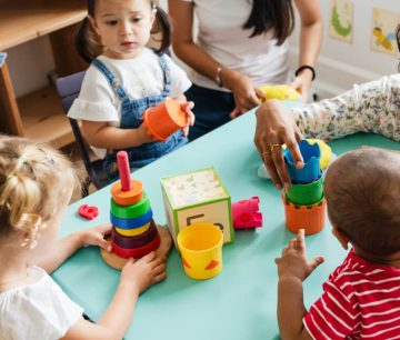 Teacher and toddlers playing with stacking toys