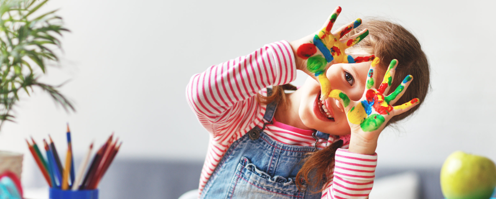 Smiling child with colorful painted hands